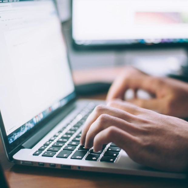 man typing on laptop