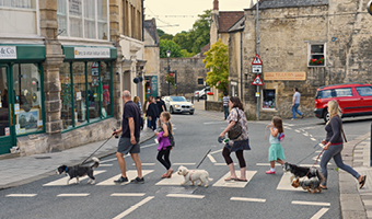 people crossing level crossing in town